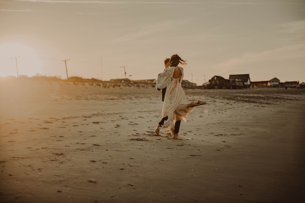 groom-picking-bride-twirling-beach-elopement-photography-northcarolina-obx-outerbanks-banks-nags-head-nc.jpg