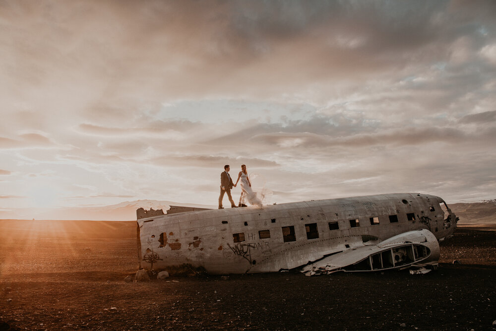 bride and groom on top of the crashed plane site in Iceland