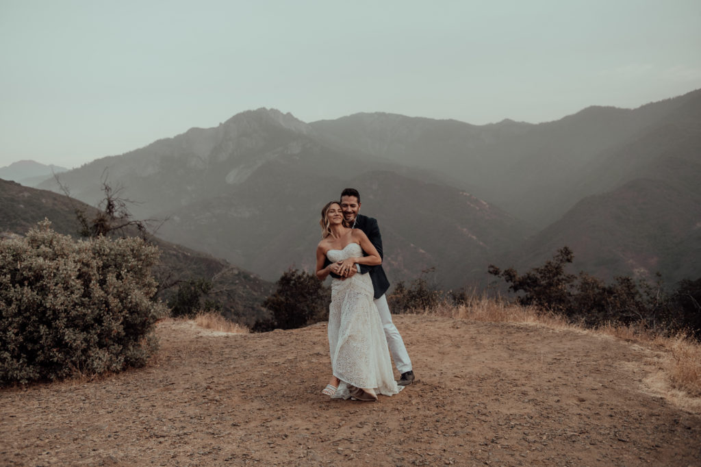 groom hugging bride from the back at their elopement in Sequoia National Park California 