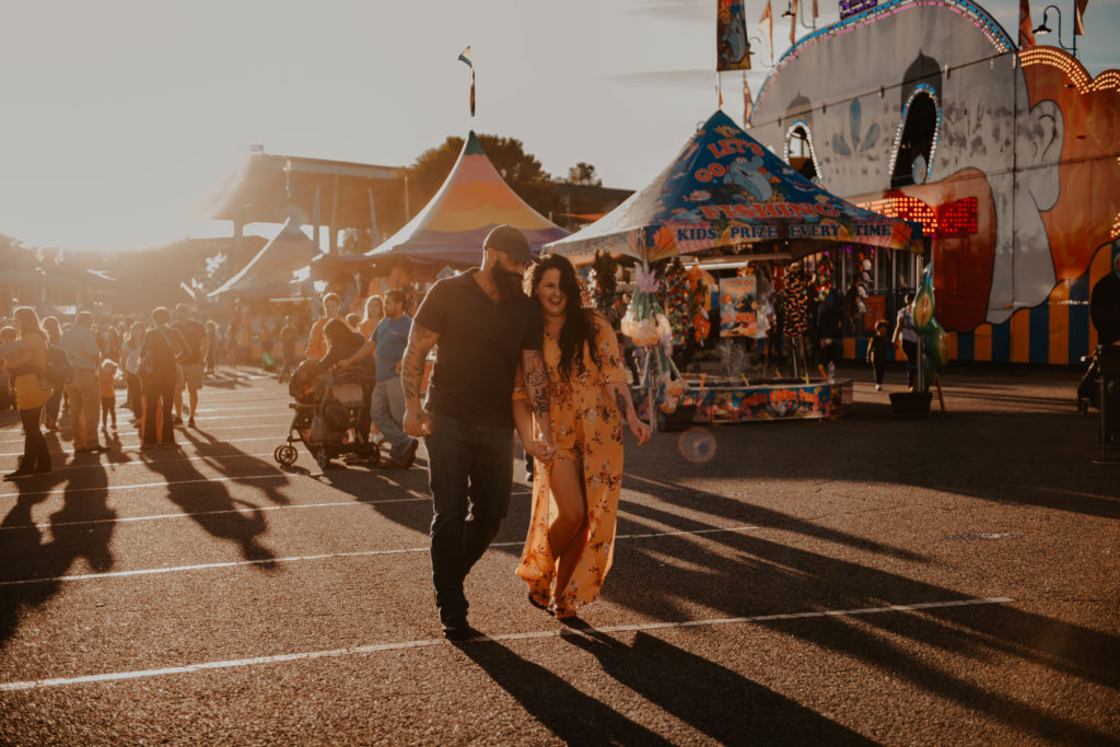 photo of the couple holding hands, laughing and walking taken at the fair in Georgia 