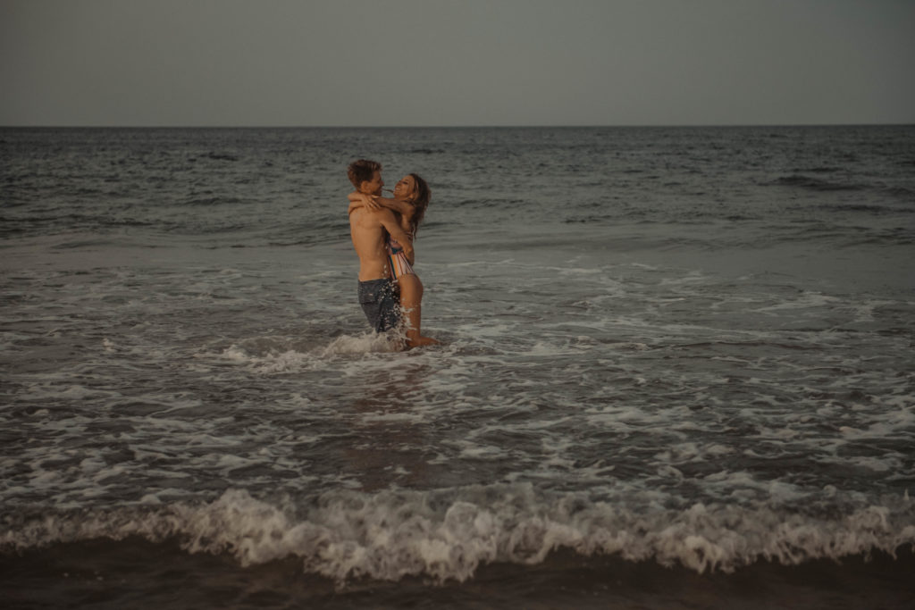 photo of the couple in swimsuit playing in the ocean at the beach taken in acworth gerogia 