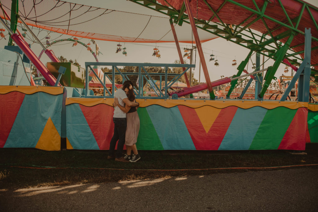 photo of the couple hugging and laughing taken at a fair in cumming georgia