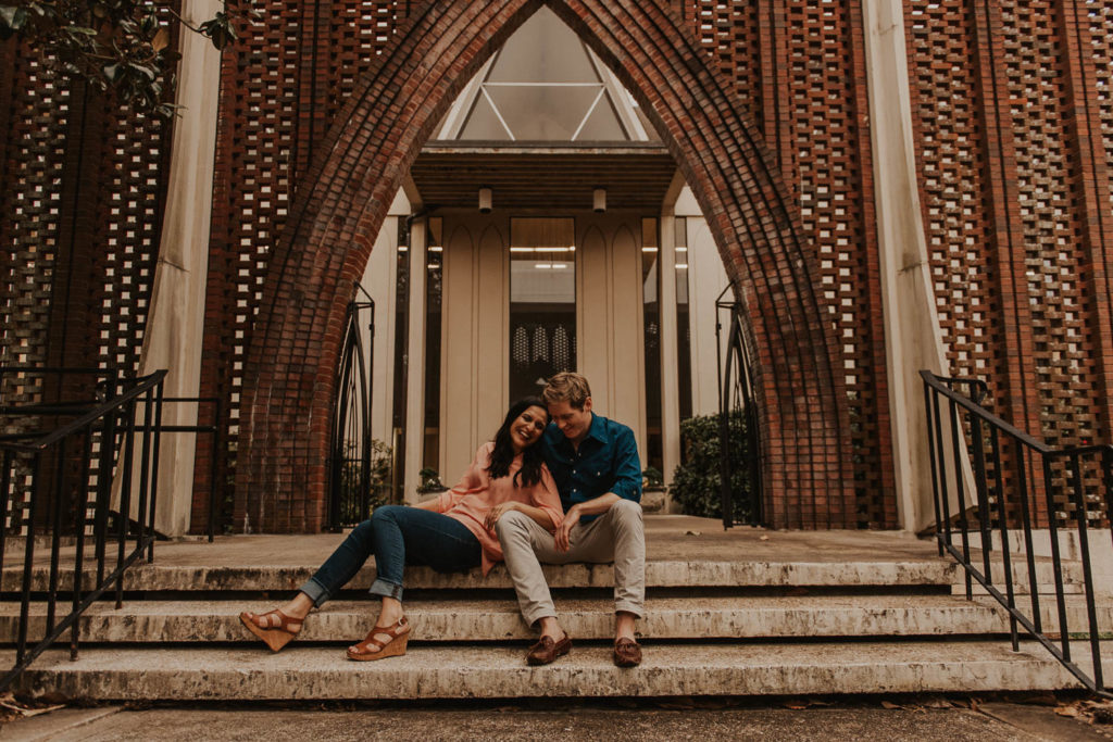 photo of the couple sitting on the stairs and laughing taken at Agnes Scott college in Atlanta 