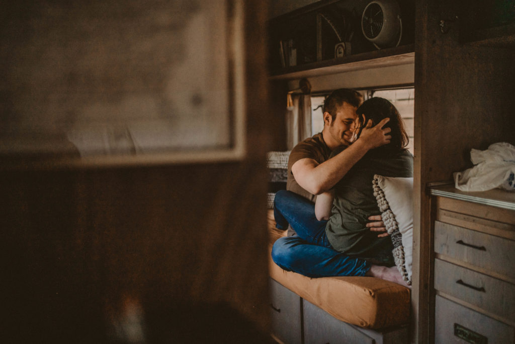 photo of the couple sitting at a couch and hugging taken at a vintage airstream in downtown atlanta