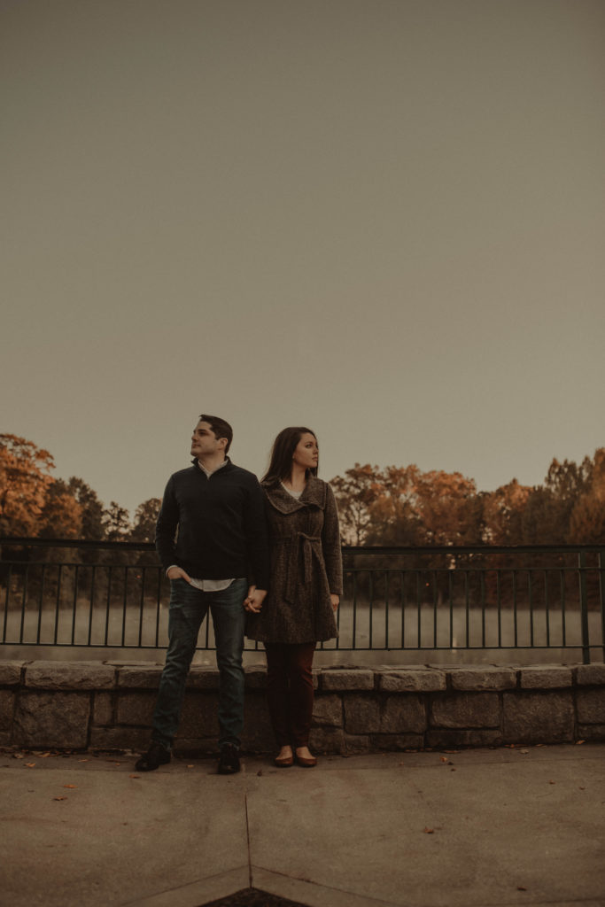 Photo of a couple standing next to each other and looking in the opposite direction