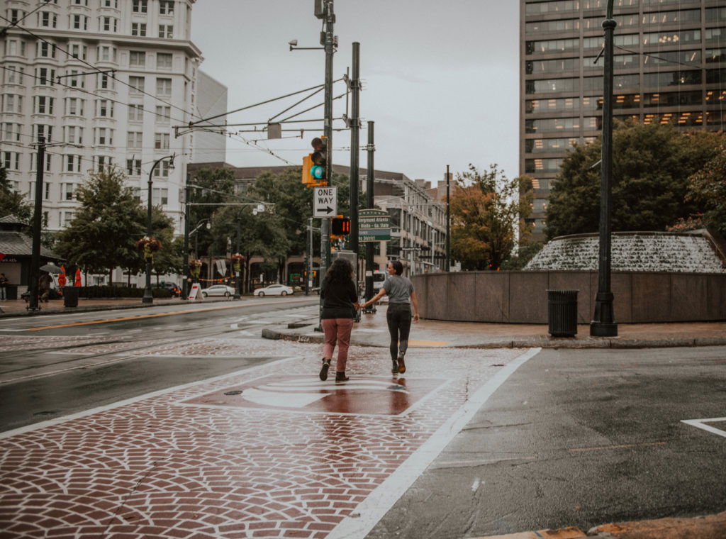 photo of a couple holding hands and running in the rain taken in downtown atlanta 