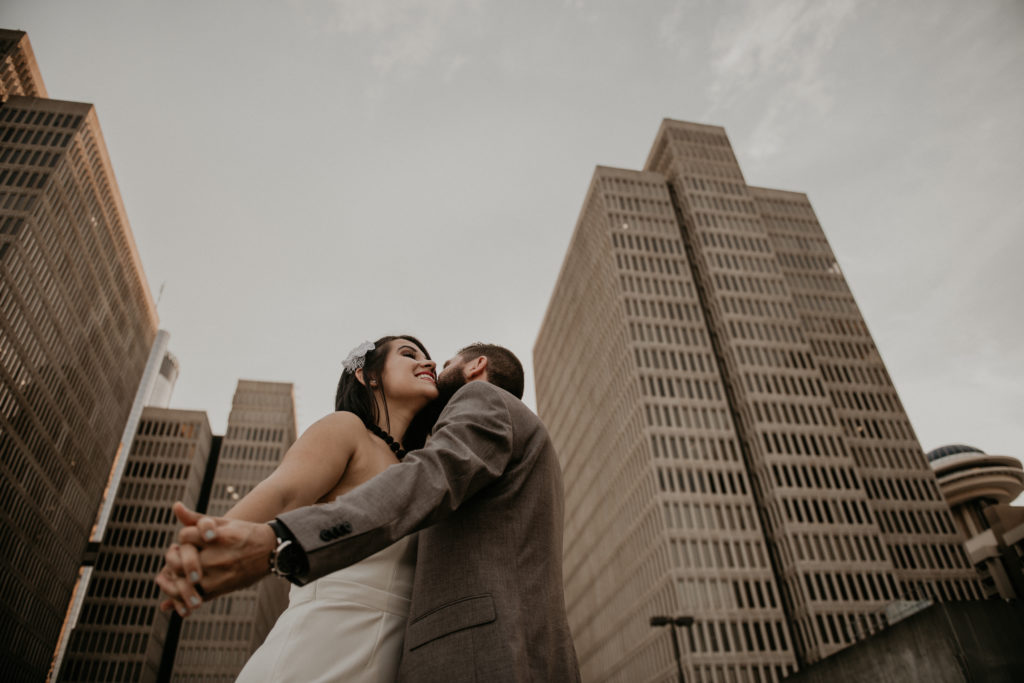 photo of the couple hugging and kissing taken at a rooftop in downtown atlanta 