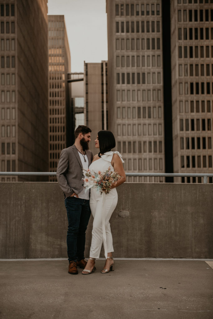 bride and groom looking at each other and bride holding the bouquet on a rooftop elopement in downtown georgia