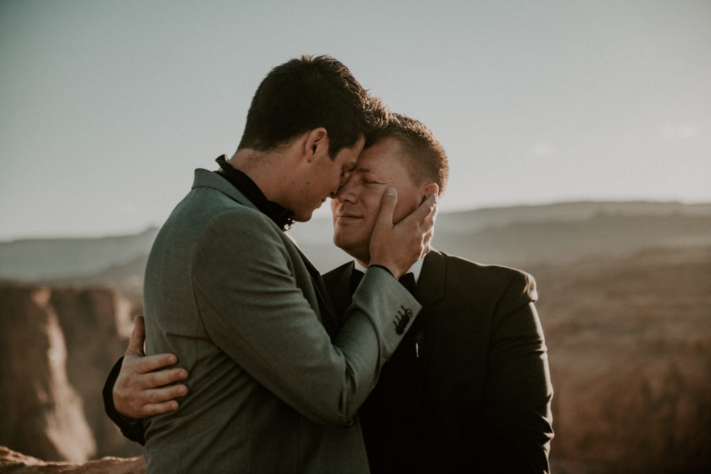 two grooms holding each other and kissing during their elopement at Horseshoe bend