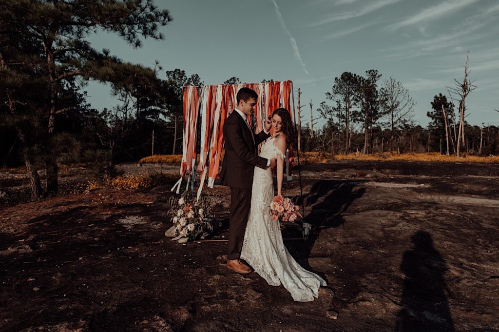 bride and groom standing in front of the arch for an arabia mountain elopement