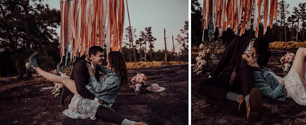 bride and groom sitting on the ground kissing and laughing at an arabia mountain elopement