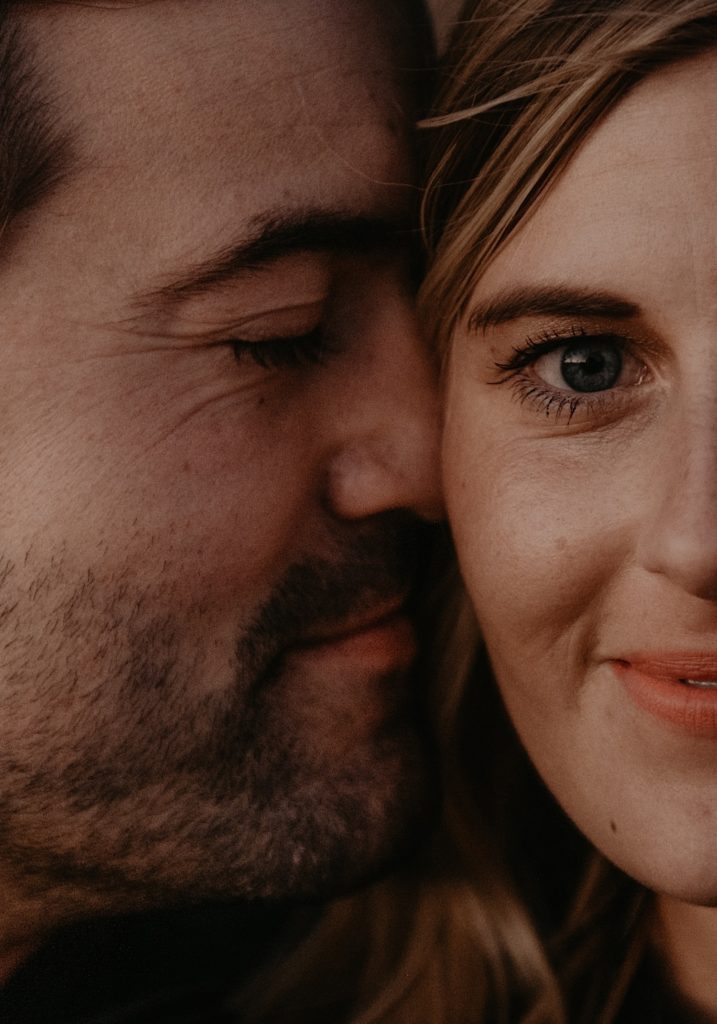 close up Photo of the groom kissing the bride's cheek and the bride looking at the camera taken at a Joshua tree elopement