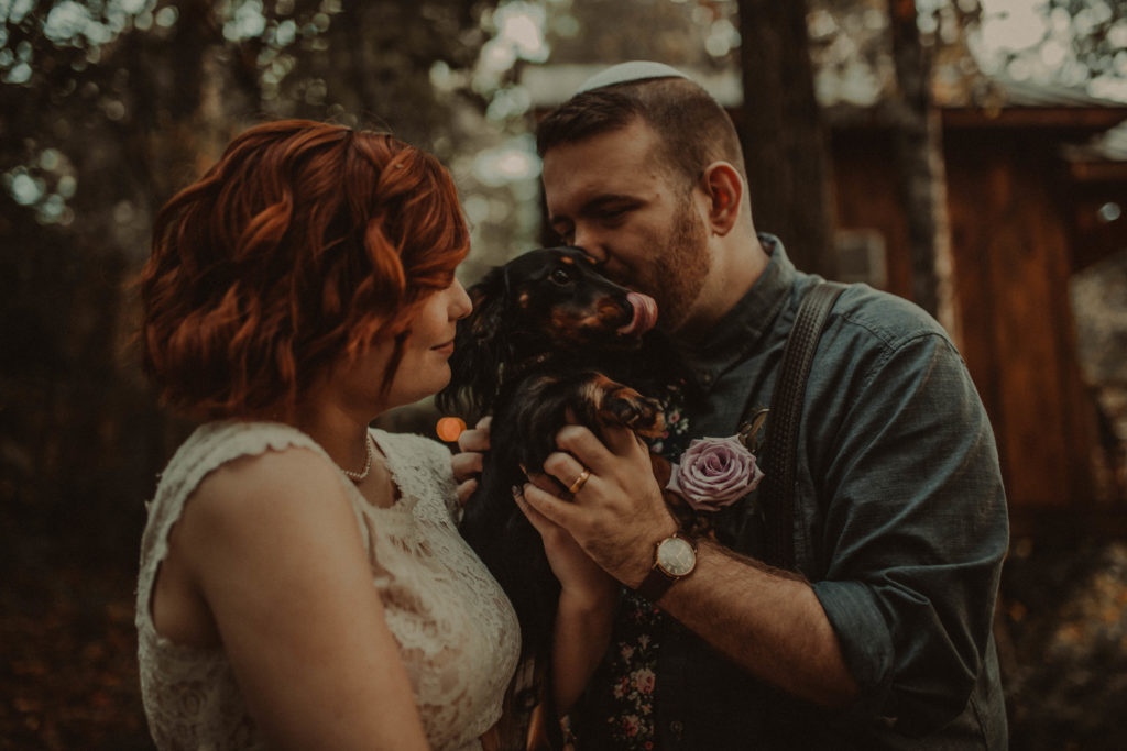 bride and groom kissing their puppy taken an airbnb elopement in north georgia
