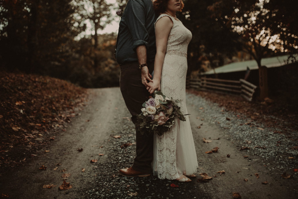 bride and groom standing back to back and holding hands taken at an airbnb elopement in georgia
