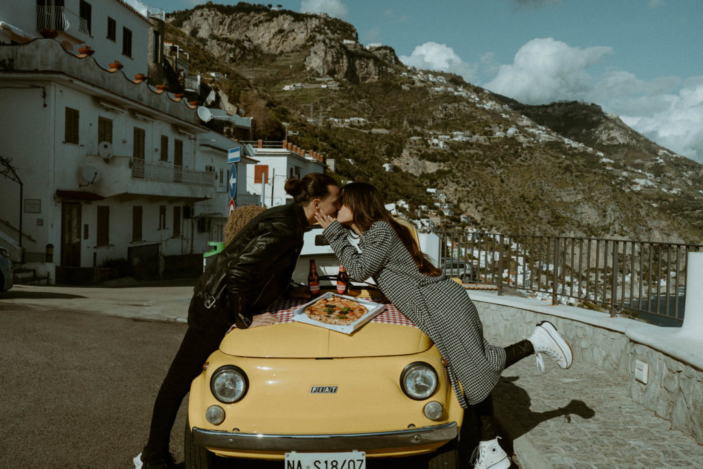Couple kissing during a pizza picnic in Italy