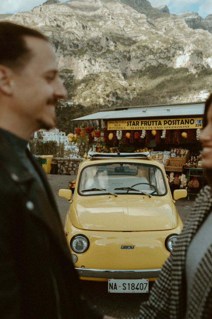 Couple looking at each other in front of a fruit stand in Positano