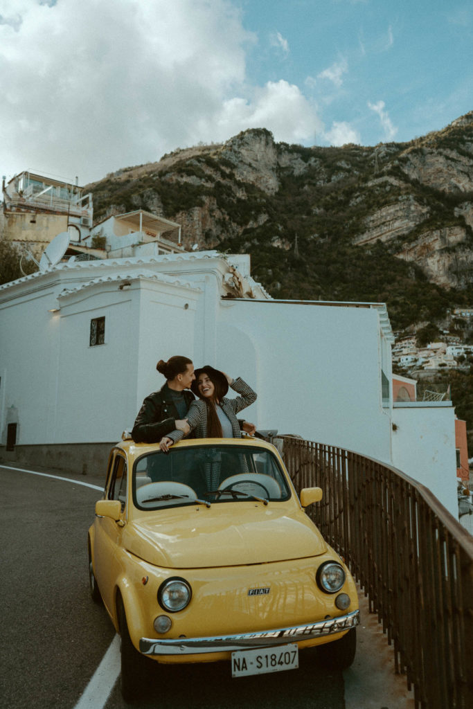 Couple standing inside a vintage fiat taken in Positano ITaly