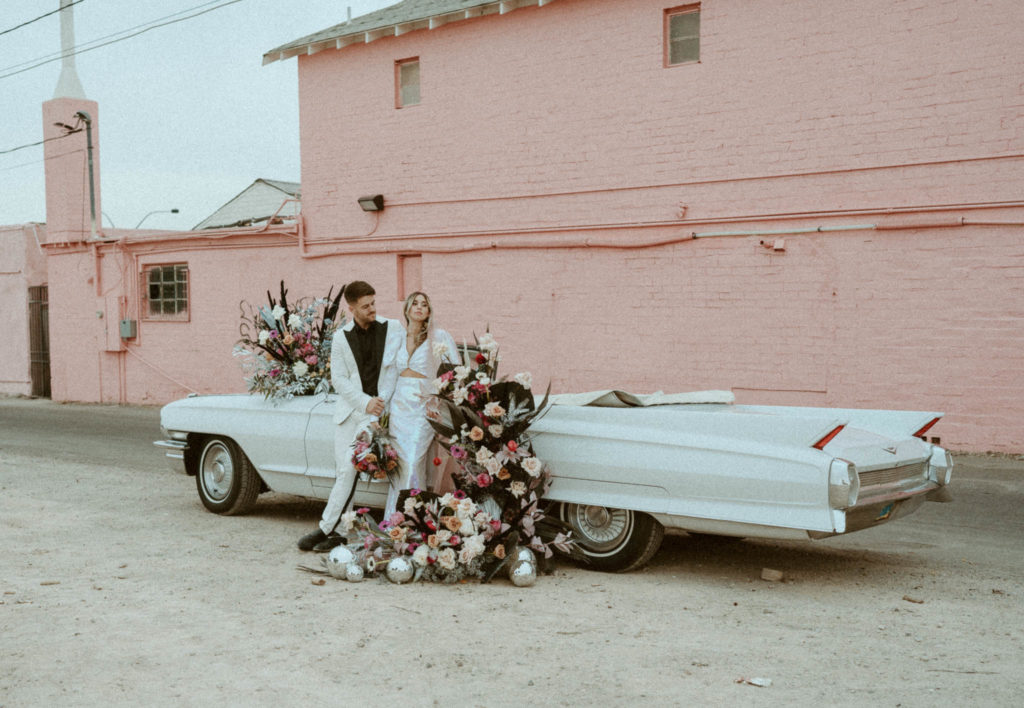 editorial photo of the couple posing with their car taken at their las vegas elopement