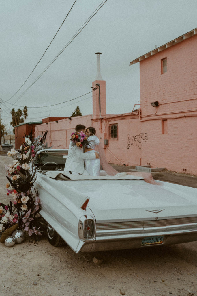 photo of the couple standing in their car and kissing at their las vegas elopement