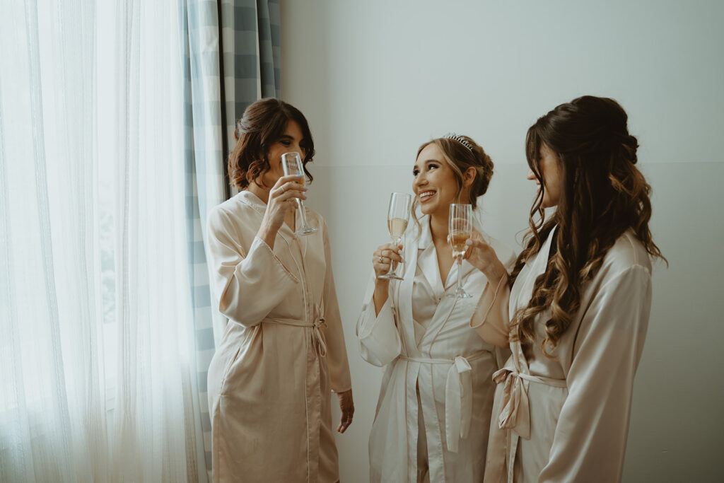 Bride and bridesmaids drinking champagne