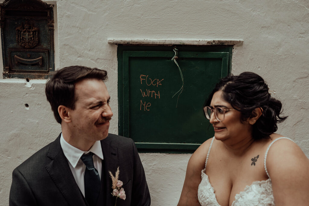 Bride and groom posing with funny graffiti 