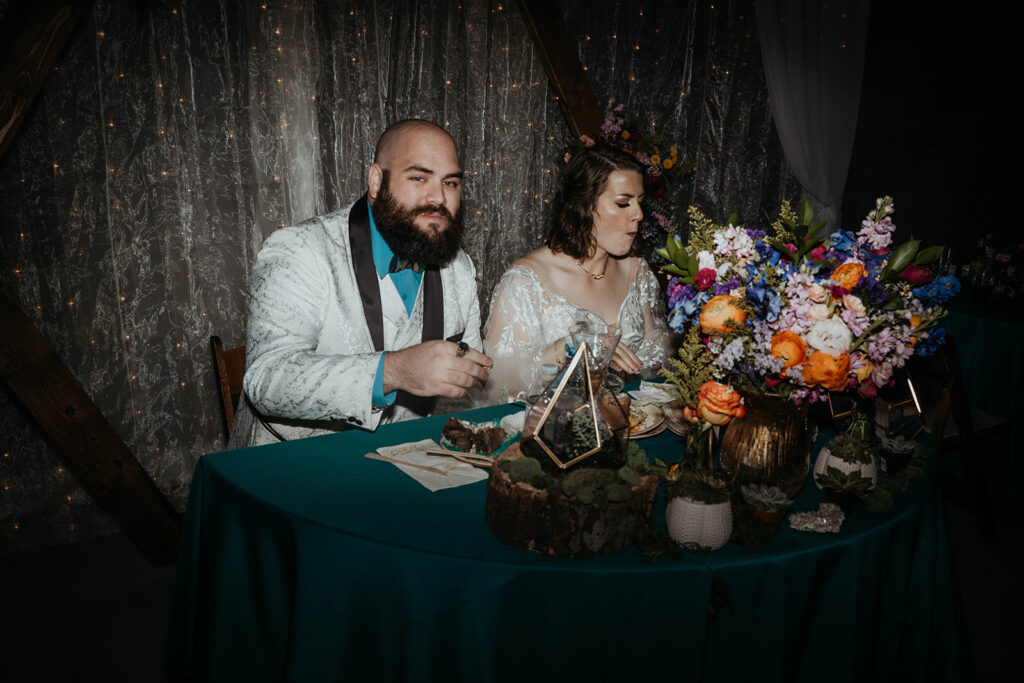 Bride and groom eating at sweethearts table