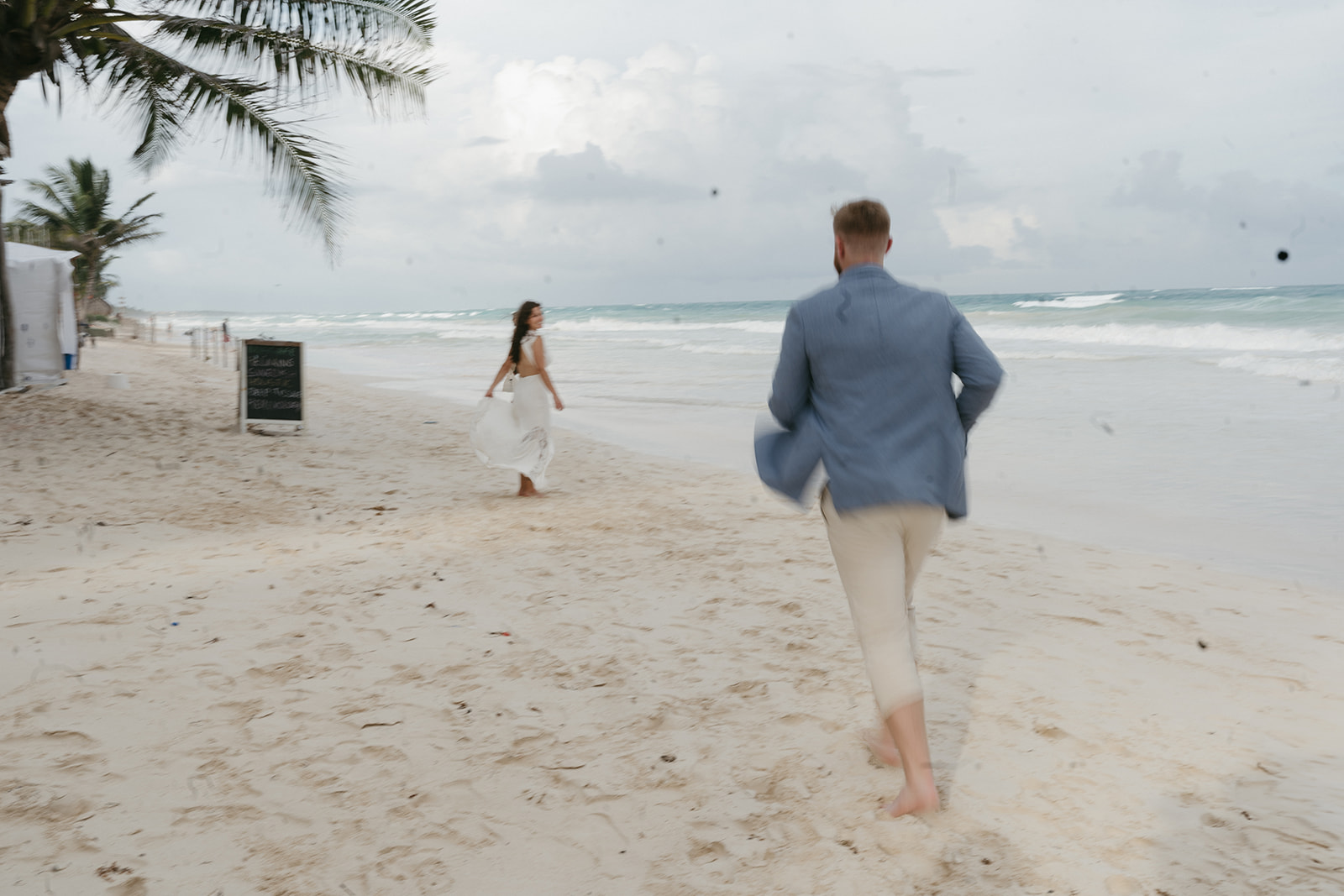 Bride and groom running on the beach