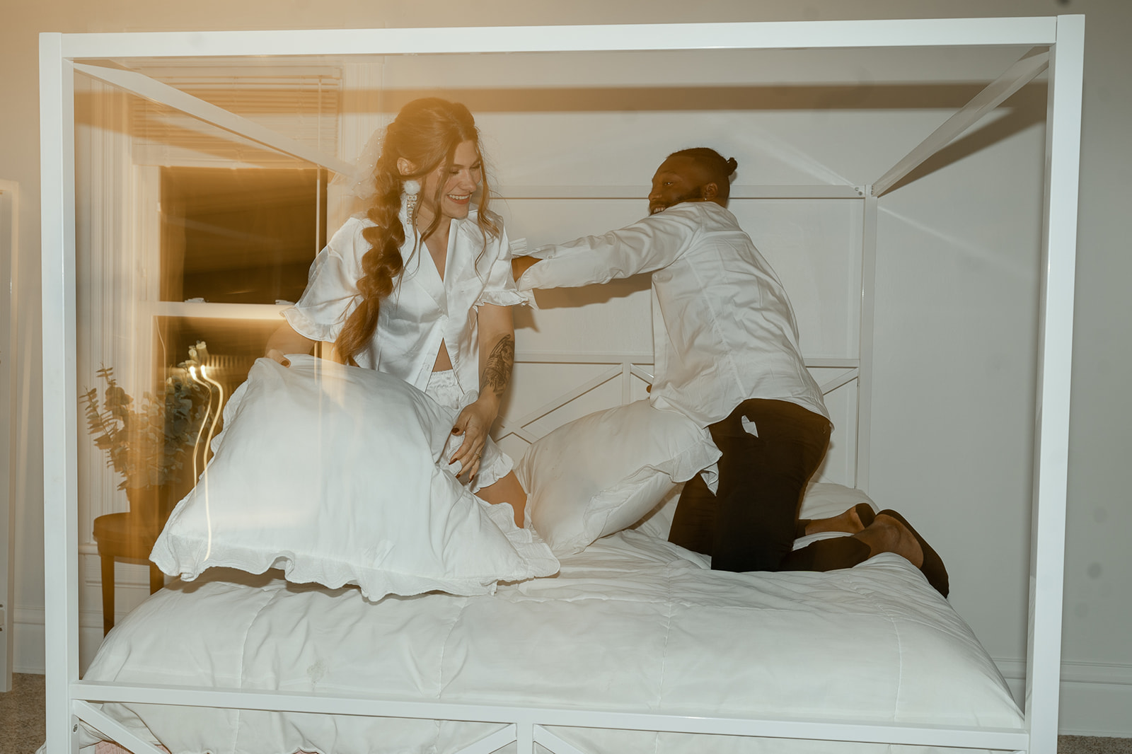 Bride and groom having a pillow fight at The Wildflower 301 Mansion