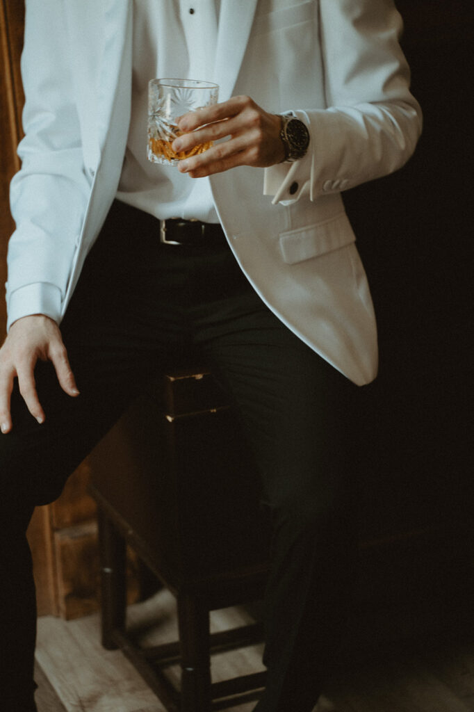 Groom holding a glass of whiskey