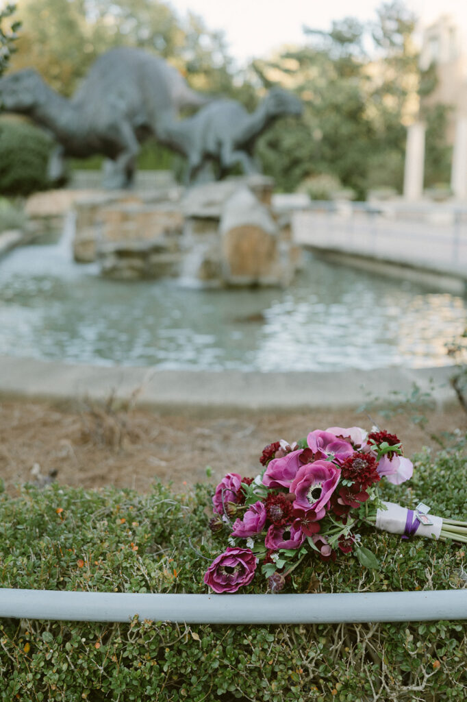 Wedding bouquet detail shot in front of dinosaur sculptures.