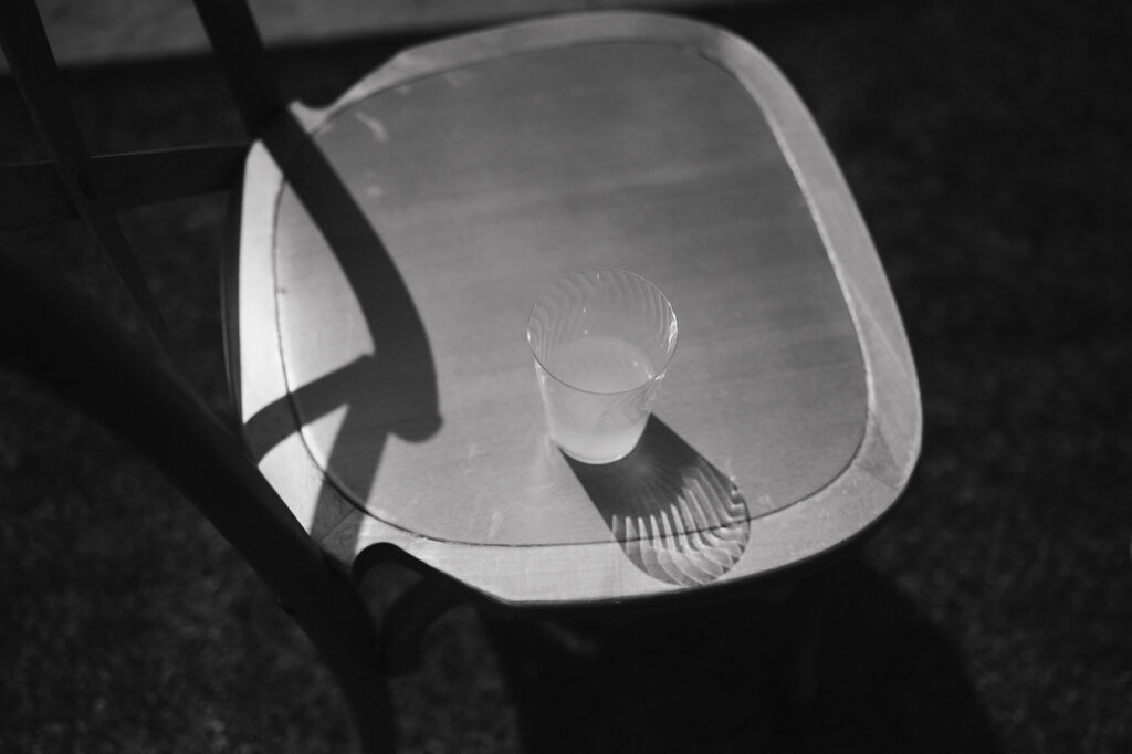 Black and white photo of a drink sitting on a chair during cocktail hour