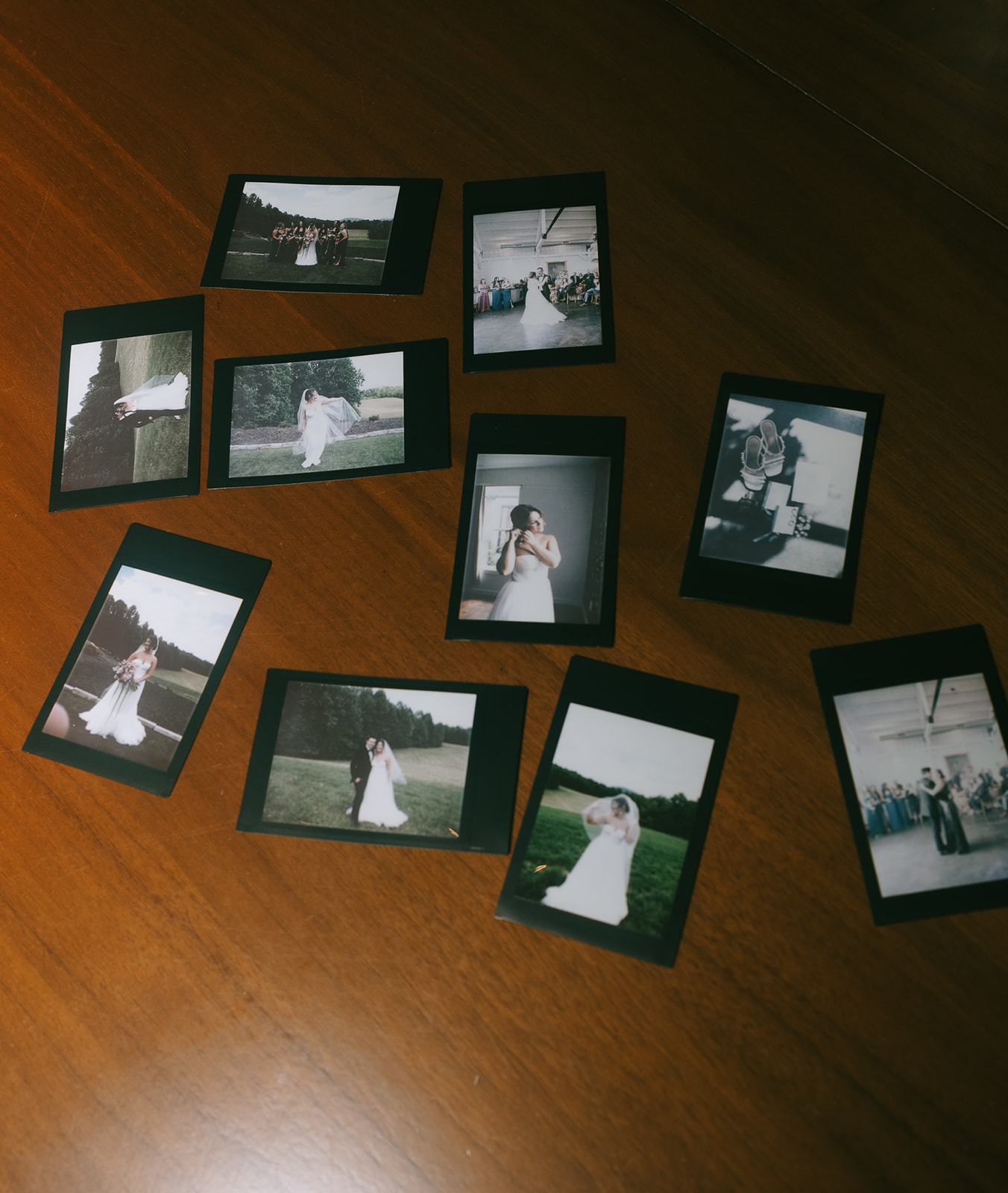 Polaroid photos photos laying out on a table during a wedding reception. 