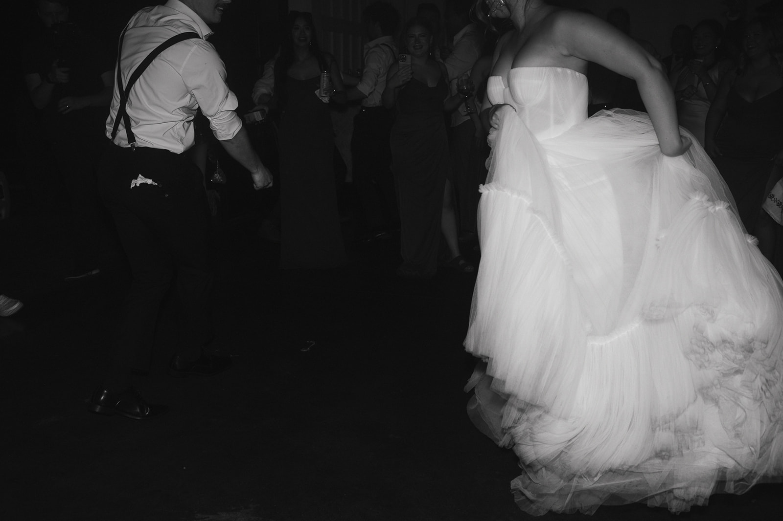 Black and white photo of a bride and groom dancing together during their wedding reception