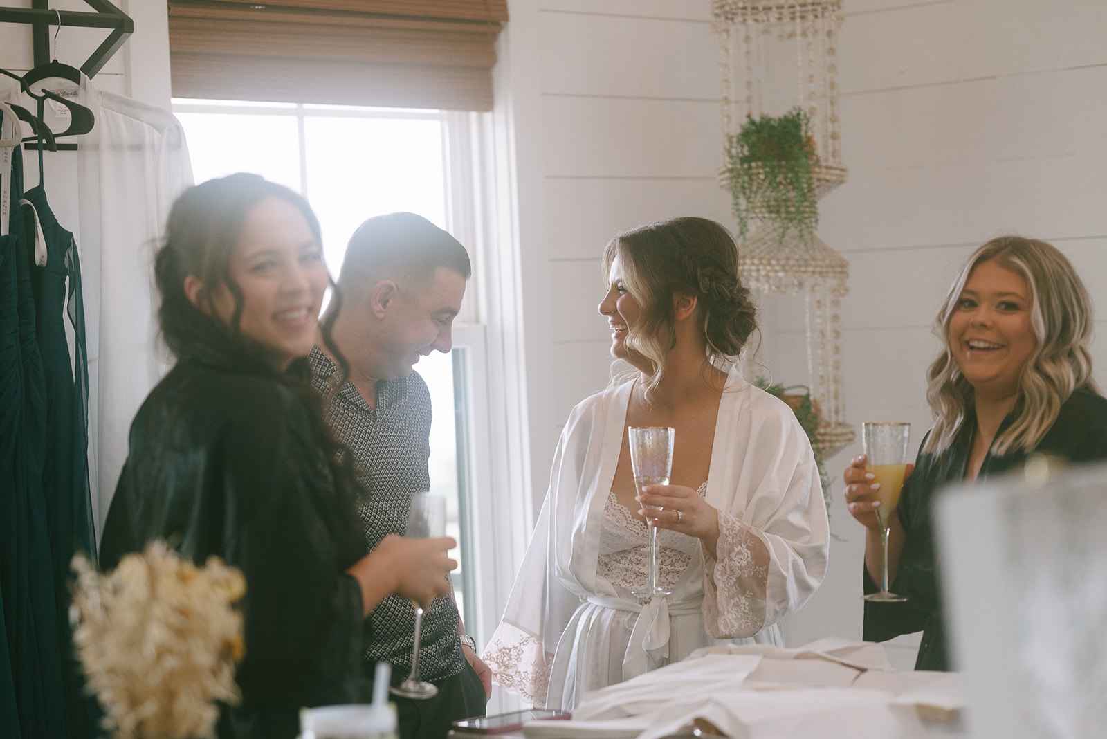 Bride and her bridesmaids sharing champagne 