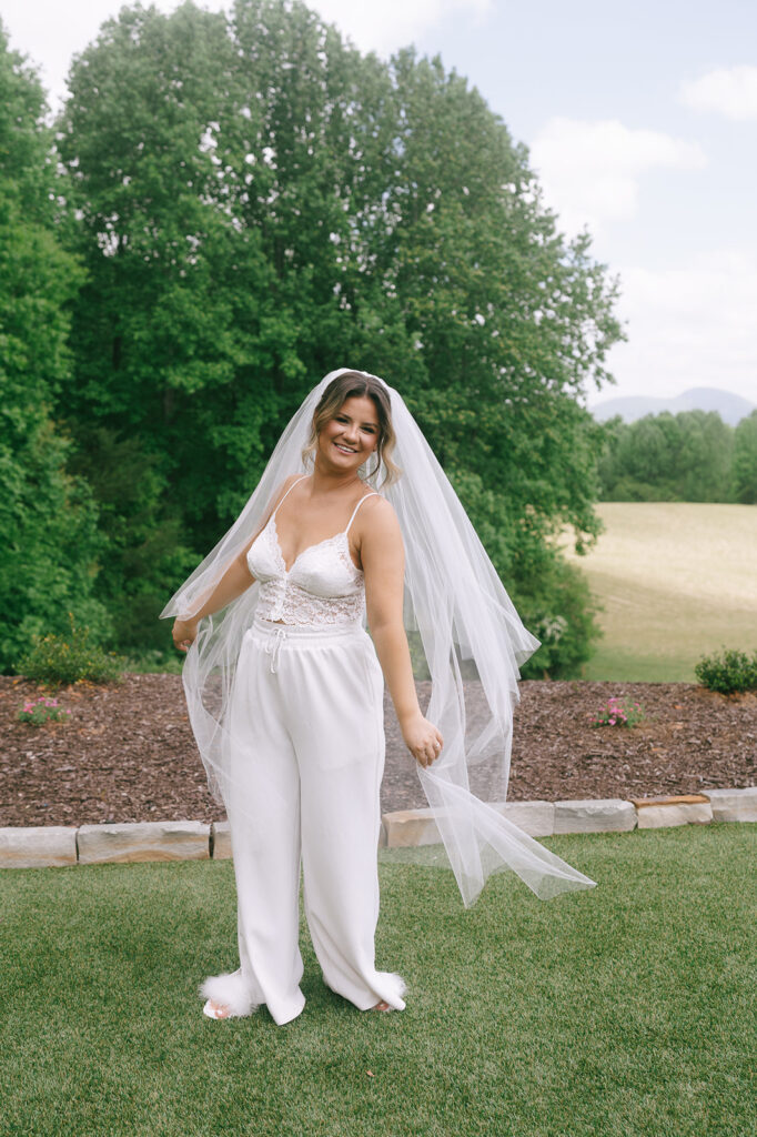 Bride wearing her white pajama set with her veil