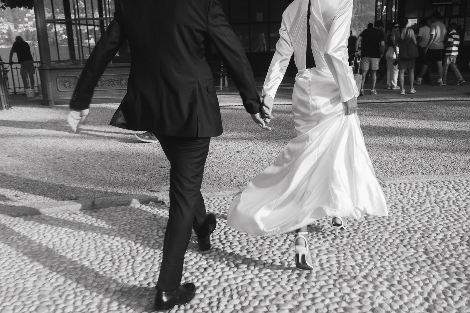 Black and white photo of a bride and groom running