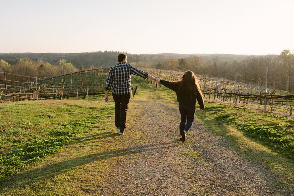 couple holding hands walking around montaluce winery 