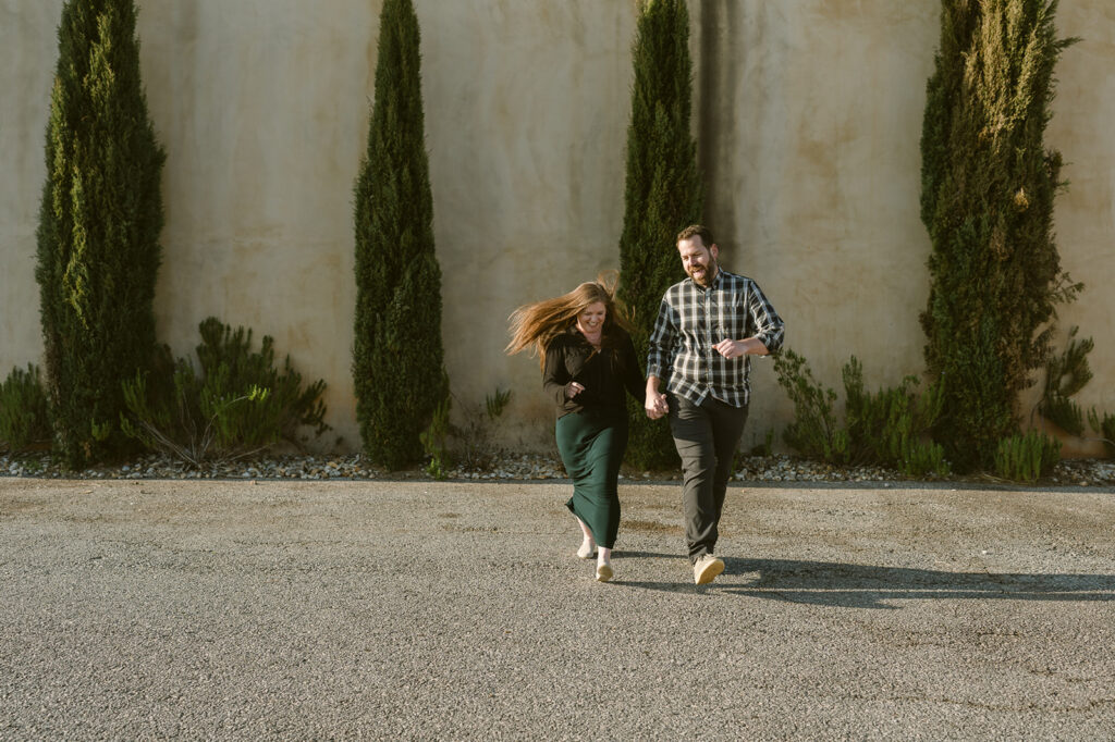 couple holding hands running during their photoshoot 