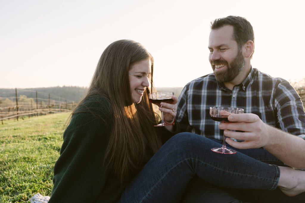 couple sharing a glass of wine during their picnic themed engagement session