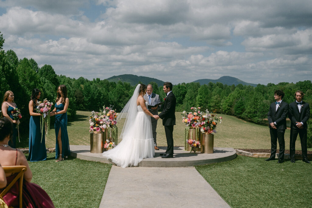 bride and groom holding hands at their wedding ceremony 