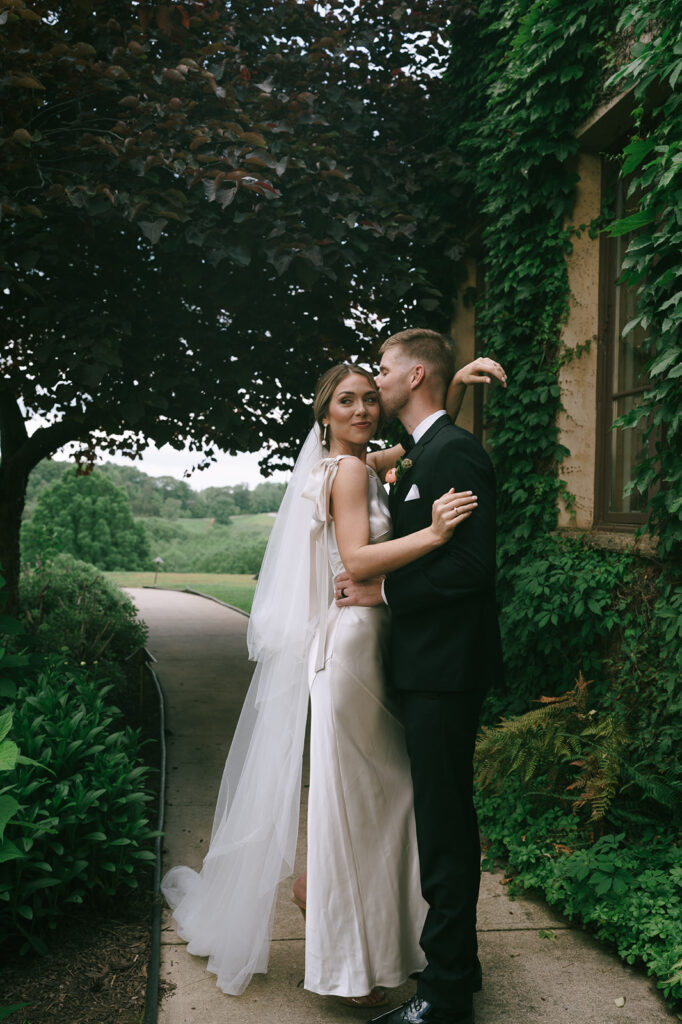 groom kissing the bride on the forehead 