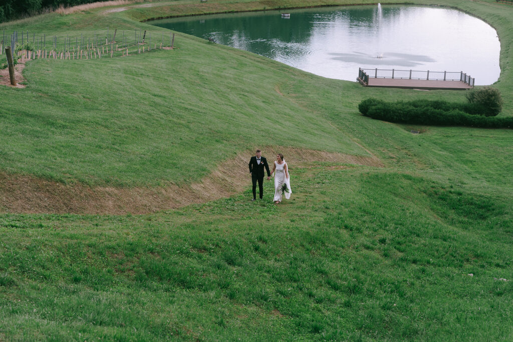 bride and groom holding hands walking around their wedding venue 