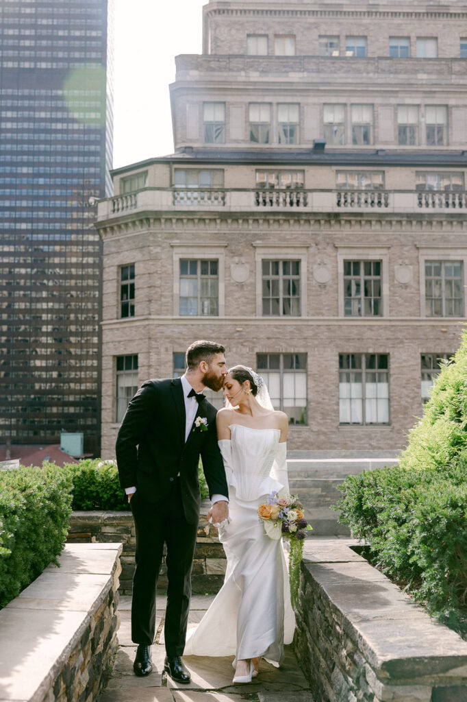 groom kissing the bride on the head 