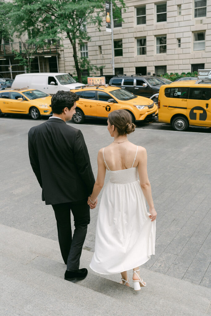 couple holding hands walking around new york