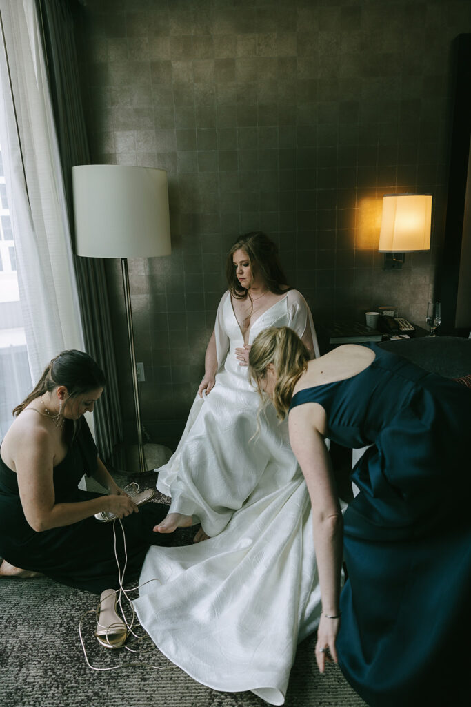 bride putting on her wedding shoes