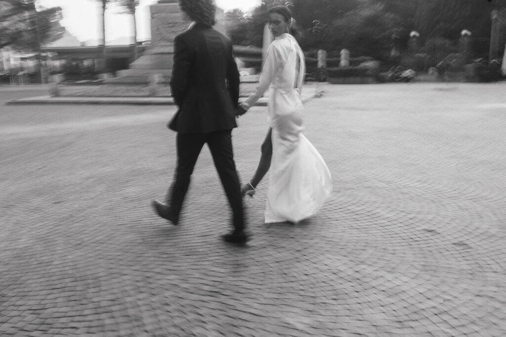 couple holding hands walking around lake como