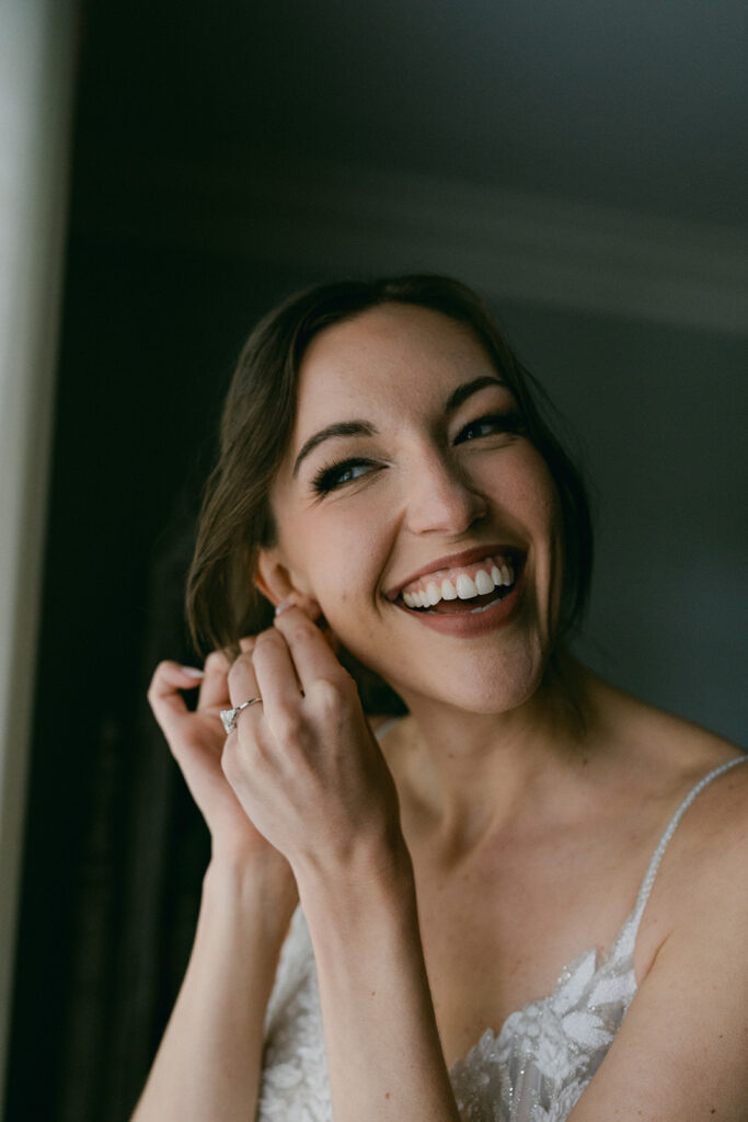 bride putting on her wedding earrings