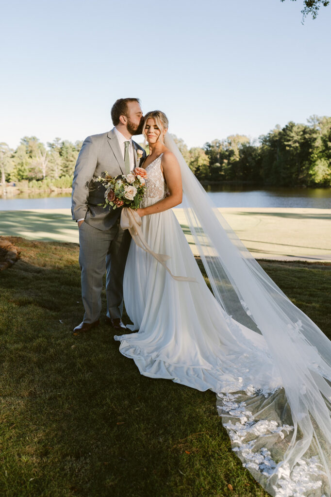 groom kissing the bride on the forehead 