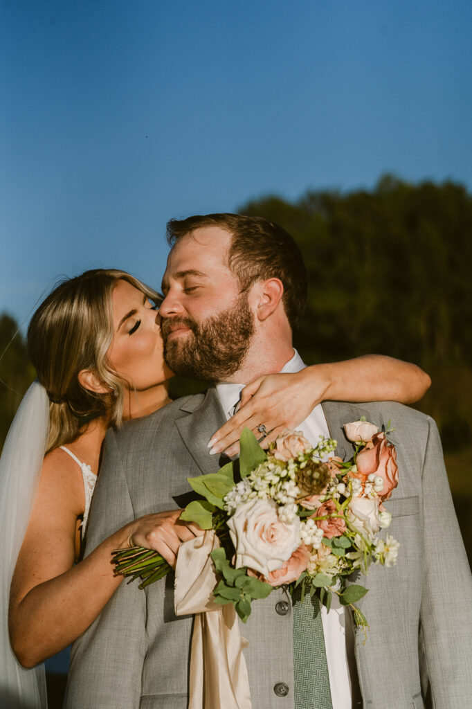 bride kissing the groom on the cheek