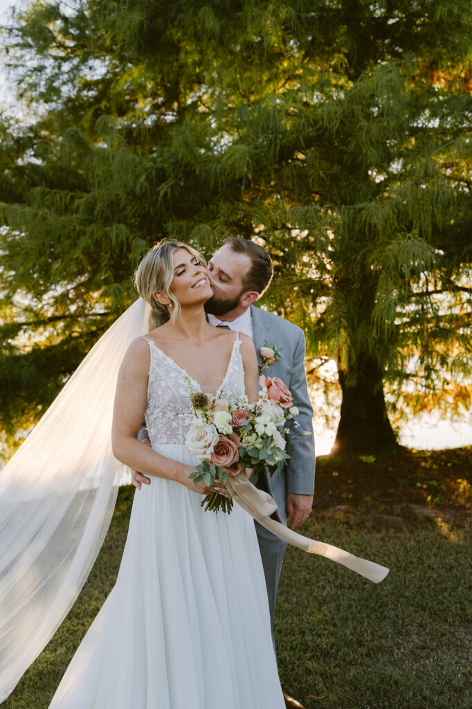 groom kissing the bride on the cheek